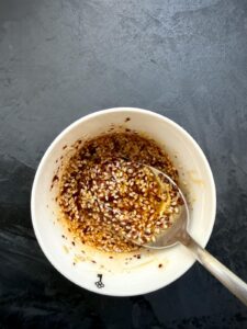 Заправка для салата из огурцов по-корейски с кунжутом, рыбным соусом, чесноком и хлопьями перца.